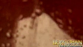 Lexy Lohan, a blonde babe, fingers her shaved pussy while bathing in the shower.