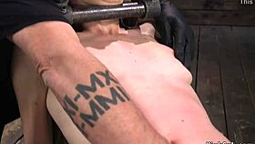 brunette locked in metal device whipped by master in rough bdsm session.