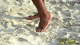Giggles splashes her petite feet in the wet beach sand while sucking toes