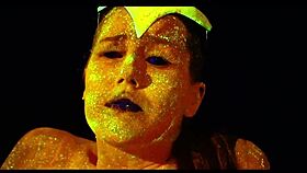 The glow in the dark goddess fingers her shaved pussy with a dildo.