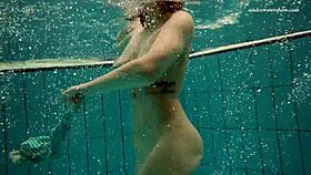 dasha dives underwater in a bikini, revealing her petite naked body by the pool