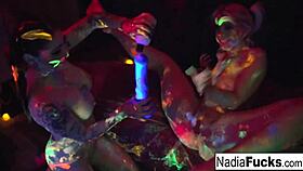 Black-Light Babes Nadia White And Ophelia Suck Off A Colorful Cock?