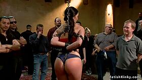 Stunning brunette slut endures public fisting bondage