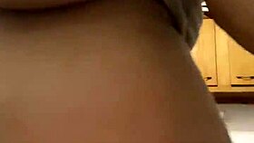 Latina milf enjoys washing dishes in the kitchen with a smile.