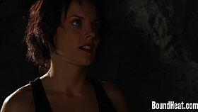 Two bound busty lesbian slaves feel the whip's sting in the garage