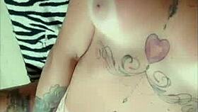 tattooed redhead shows tan lines close up