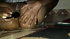An amateur black mama squirts from eggplant anal, soaking the floor.