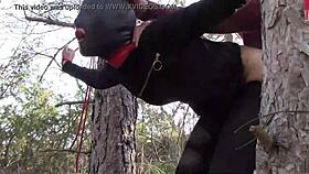 Tied To A Tree Outdoors In Pantyhose And High Ankle Boots