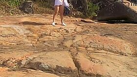 a beautiful young girl is WATCHED having sex in public on the beach rocks and INTERRUPTED by a third individual