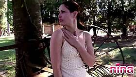 Nina, a latina teen, teases outdoors by showing her natural tits and rubbing her clit while masturbating.