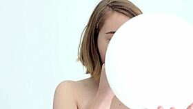 Young babe intensely blows and pops her first balloon