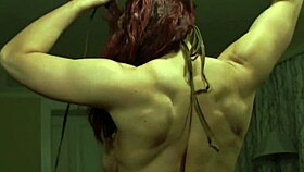 Busty redhead bodybuilder flexes while riding cock