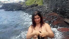My seductive stepmom flaunts her big natural tits on a public beach with daring charm.