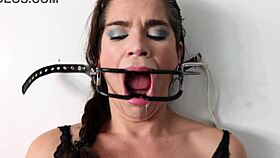 extreme gag predicament has him nailed to the wall in sloppy spitting action