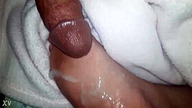 A close-up of oiled feet receiving a warm liquid splash.