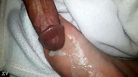 A close-up of oiled feet receiving a warm liquid splash.