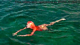 Blue water surrounds a naked skinny girl flashing outdoors