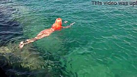 Blue water surrounds a naked skinny girl flashing outdoors