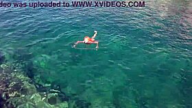 Blue water surrounds a naked skinny girl flashing outdoors