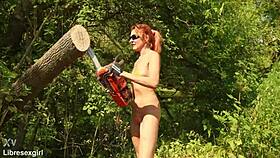 Is she sawing wood in a bikini outdoors in the forest with her small shaved tits?