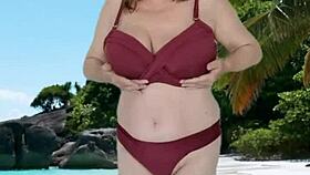 hot granny with huge natural tits teases seductively in tiny bikini.