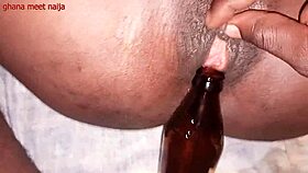 An ebony Ghana girl with onion booty fucks a malt bottle