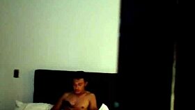 A young Colombian person is masturbating solo on vacation with his tattoos showing in the room quietly