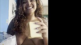 Curvy woman drinks coffee naked while chatting with the camera.