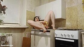 Shaved brunette stuffs bananas double in kitchen solo?