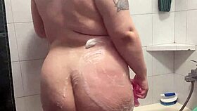 Chubby tattooed babe showers teasing her curves and wet skin beautifully
