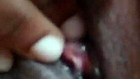She spreads her wet ebony pussy wide fingering deeply in solo play on bed