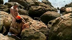 😏 Mature dude pounds exotic babe in cap and shades on seaside rocks cowgirl style 👙🌊