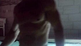 A muscular man soaks in public jacuzzi.