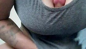 Tattooed brunette plays with dildo between her breasts casually