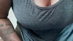 Tattooed brunette plays with dildo between her breasts casually