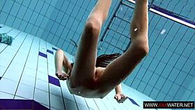 Long-haired russian brunette cutie dives underwater in public pool