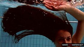 Long-haired russian brunette cutie dives underwater in public pool