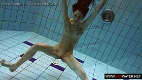 Long-haired russian brunette cutie dives underwater in public pool