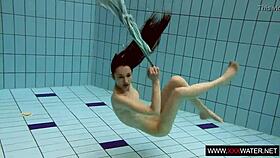Long-haired russian brunette cutie dives underwater in public pool