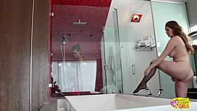 brunette steps into the shower where busty milf seduces her into intense scissoring climax