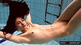 Long-haired russian brunette cutie dives underwater in public pool