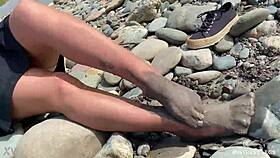 Come see my messy nylon feet up close on the riverbank in torn pantyhose