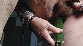 Granny teases her hairy beaver with a cucumber