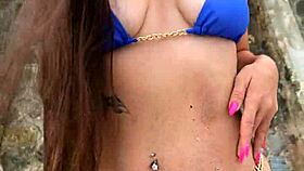 cute brunette in blue bikini dances teasingly on beach