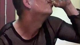 bisexual crossdresser pissing in a glass sitting on a dildo stick and shooting a cumshot drinks his piss and cum together