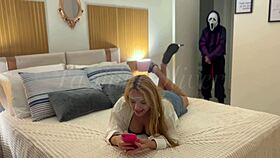 A masked person ties me and holds an object